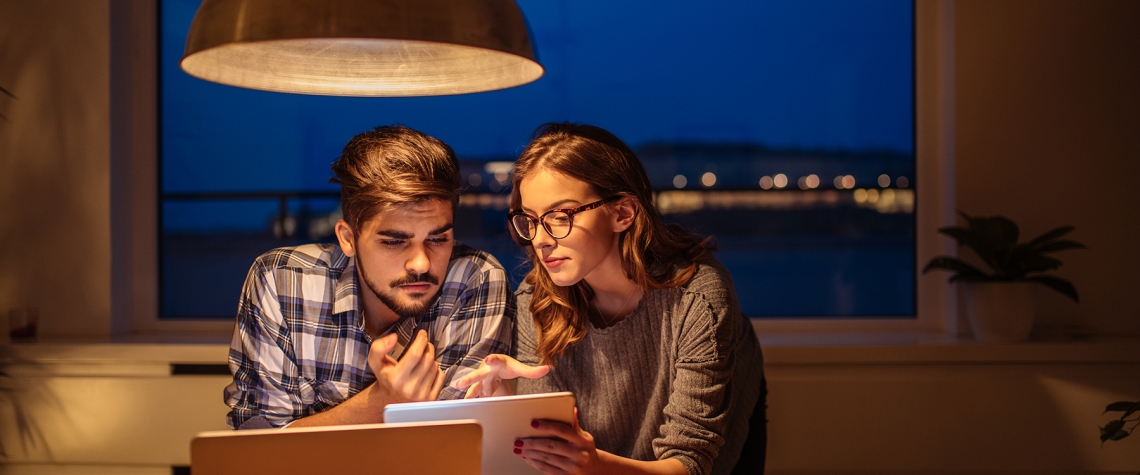 Little changes can add up to big savings Young couple calculating finances at home.