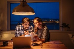 Young couple calculating finances at home.