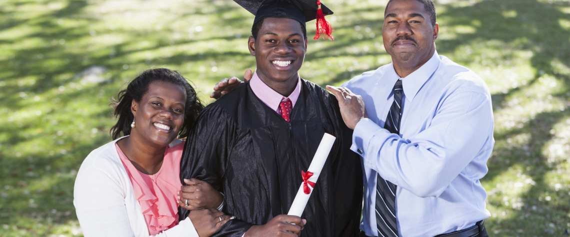 Two student loan recipients from Ephrata National Bank stand with their son at graduation