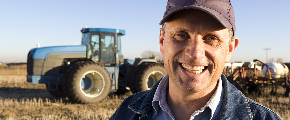 Framer in front of his tractor in the field