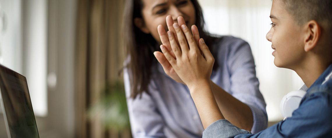 A mother and child high fiving after setting up an online account