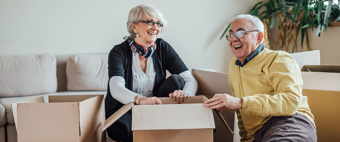 A man and woman unpacking moving boxes in a room