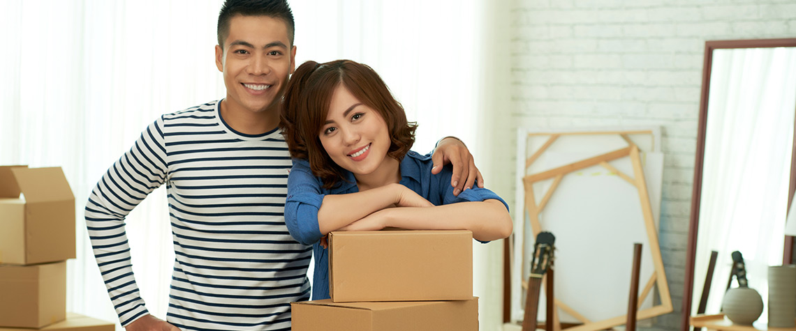 A male and female couple in a room with moving boxes