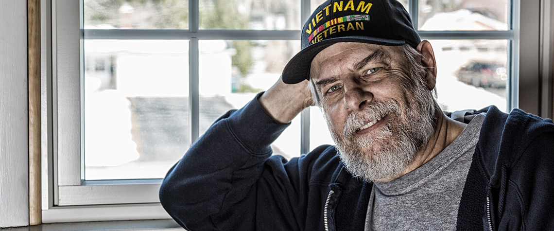 A veteran standing in front of a window