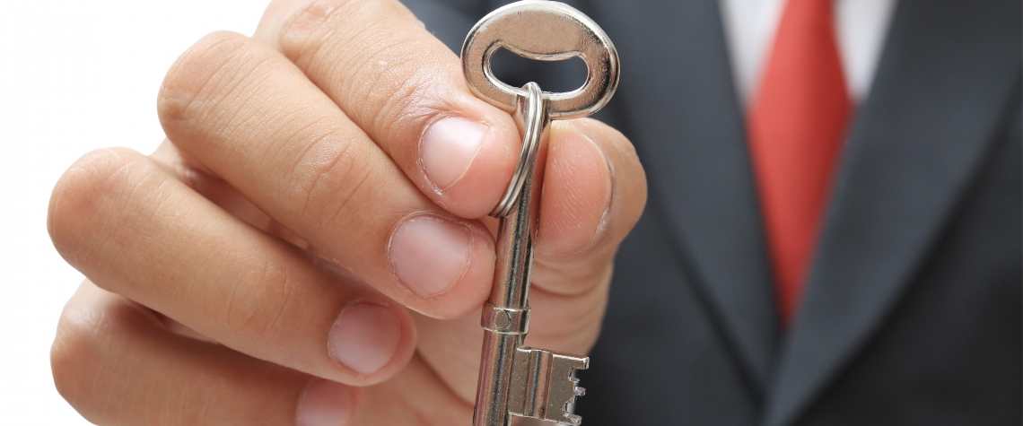 businessman showing the silver key to success