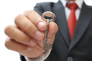 businessman showing the silver key to success