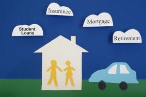 Paper cutout couple with house and car, with financial related cloud messages