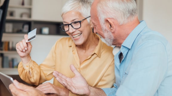 Older couple with ipad and debit card