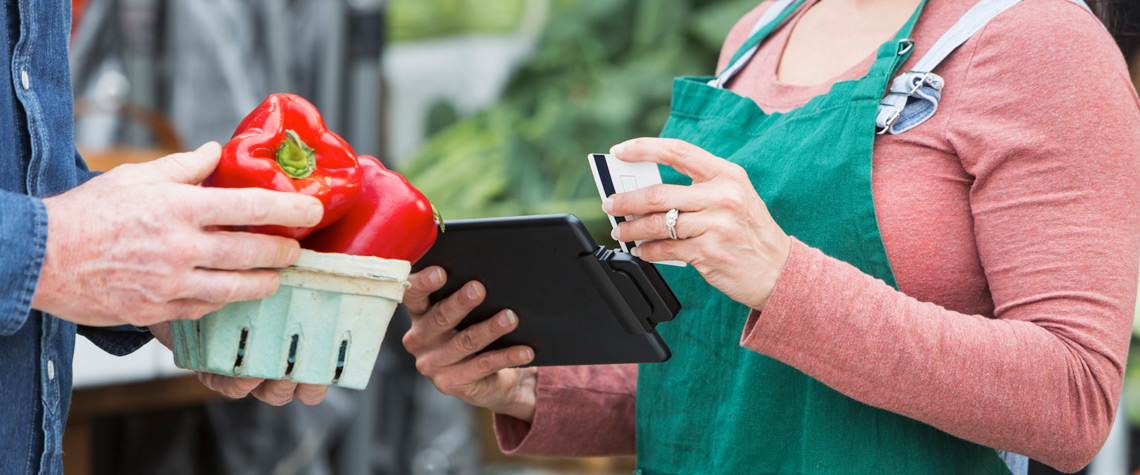 man purchasging peppers on site from a woman