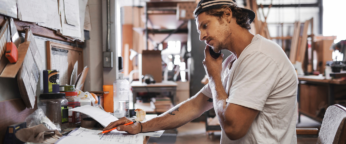 Business owner reviewing documents while on the phone