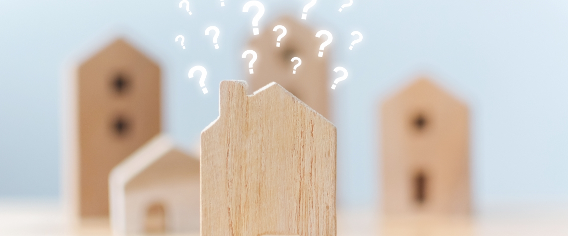 Real estate developer and managing property investment concept. Selective focus wooden houses with question mark on table Selective focus wooden houses with question mark on table