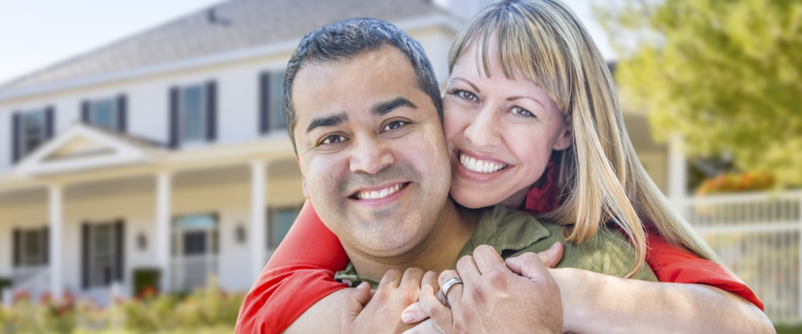 Happy Couple in Front of Beautiful House.