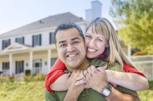 Happy Couple in Front of Beautiful House.