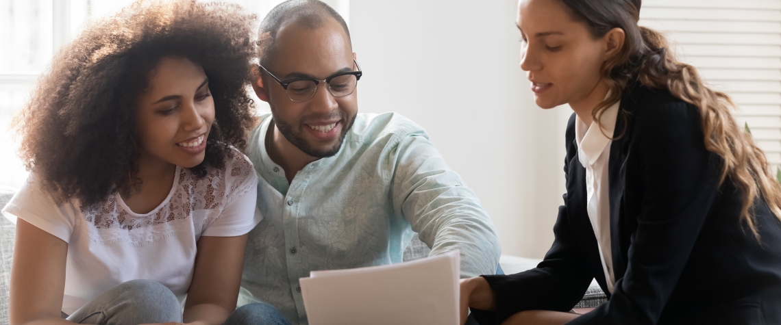 Mixed-race couple discussing contract terms during meeting with realtor Couple discusses Mortgage Contract