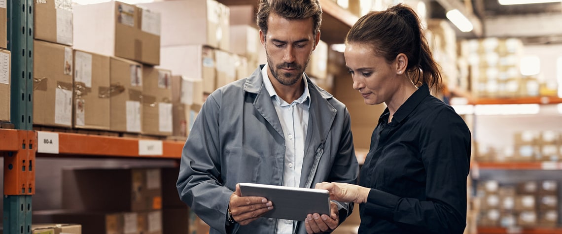 People in warehouse looking at tablet