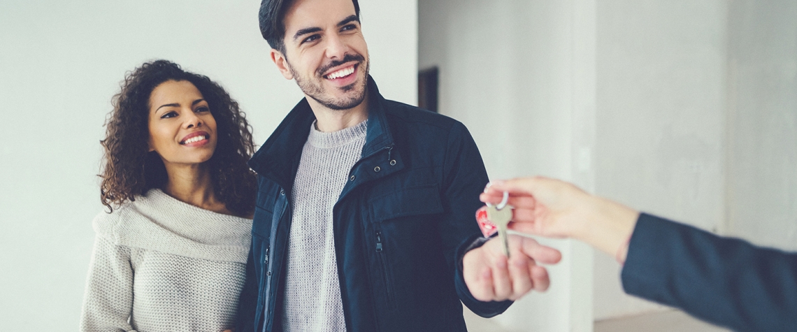 Young couple viewing new property with real estate agent