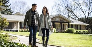 Married couple walking on pathway in front of home