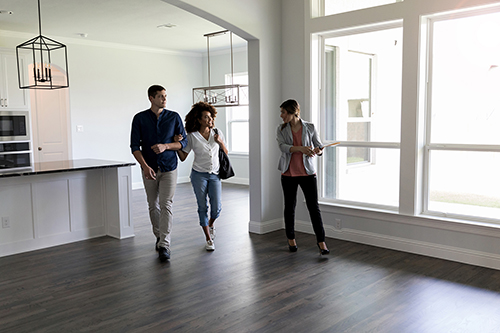 Couple walking through a house with a realtor