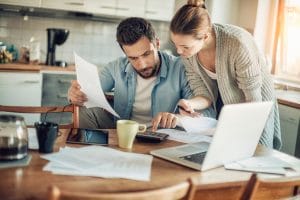 Worried young Caucasian couple going over their bills and home finances in the morning in the kitchen