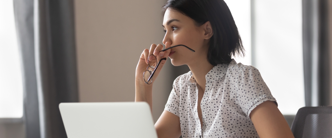 Thoughtful anxious asian business woman looking away thinking solving problem at work, worried serious young chinese woman concerned make difficult decision lost in thought reflecting sit with laptop